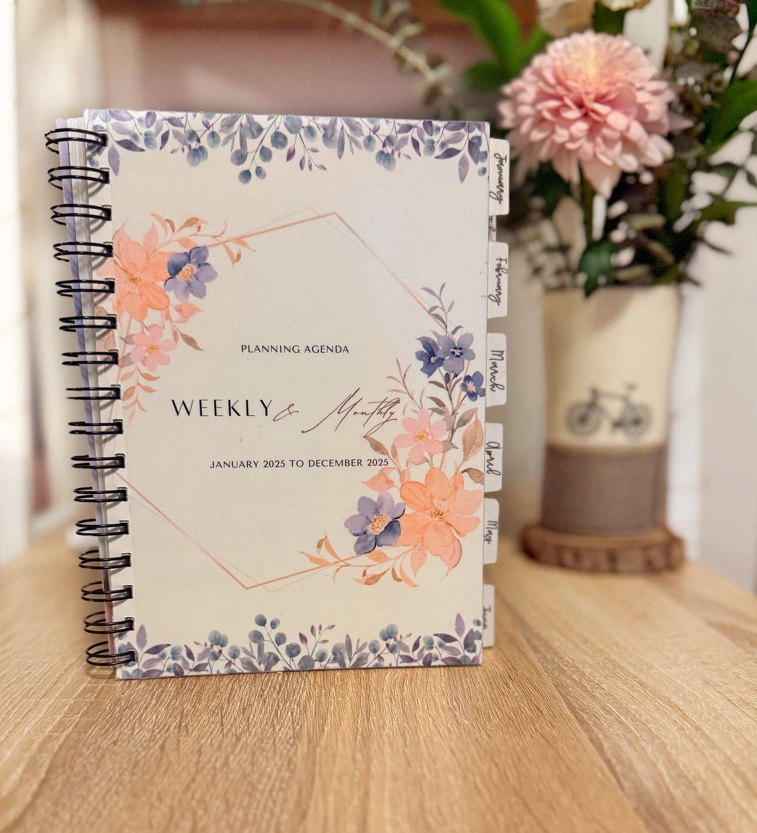 Floral planner on a wooden surface with a blurred background