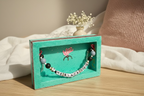 Colorful bracelet with letter beads on a green display box