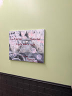 Canvas print with artistic design and text on a light green wall.