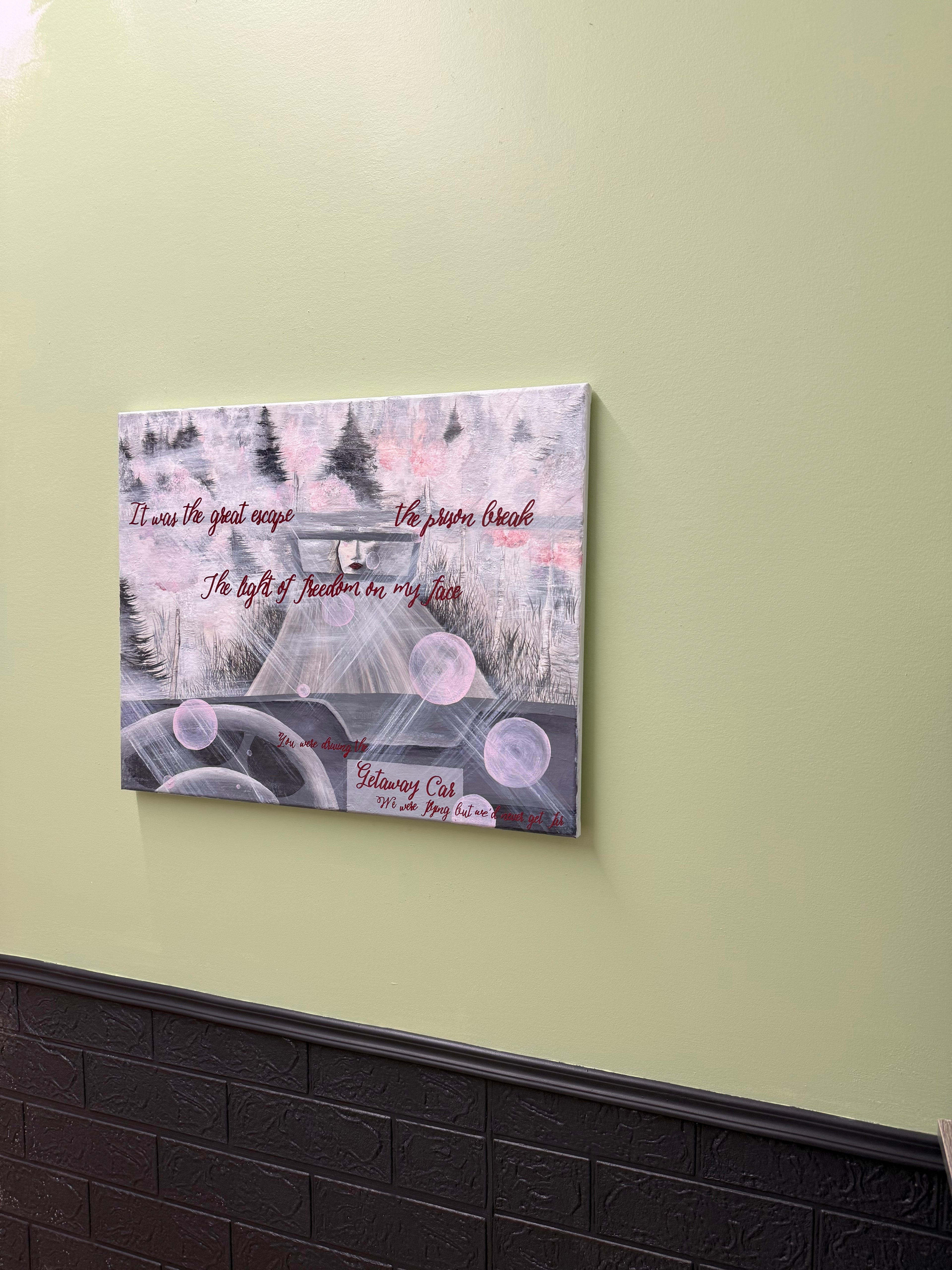 Canvas print with artistic design and text on a light green wall.