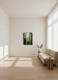 Modern living room with a large window, neutral decor, and a forest painting on the wall.