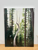 Forest scene with a curved tree trunk in the center, on a wooden surface.