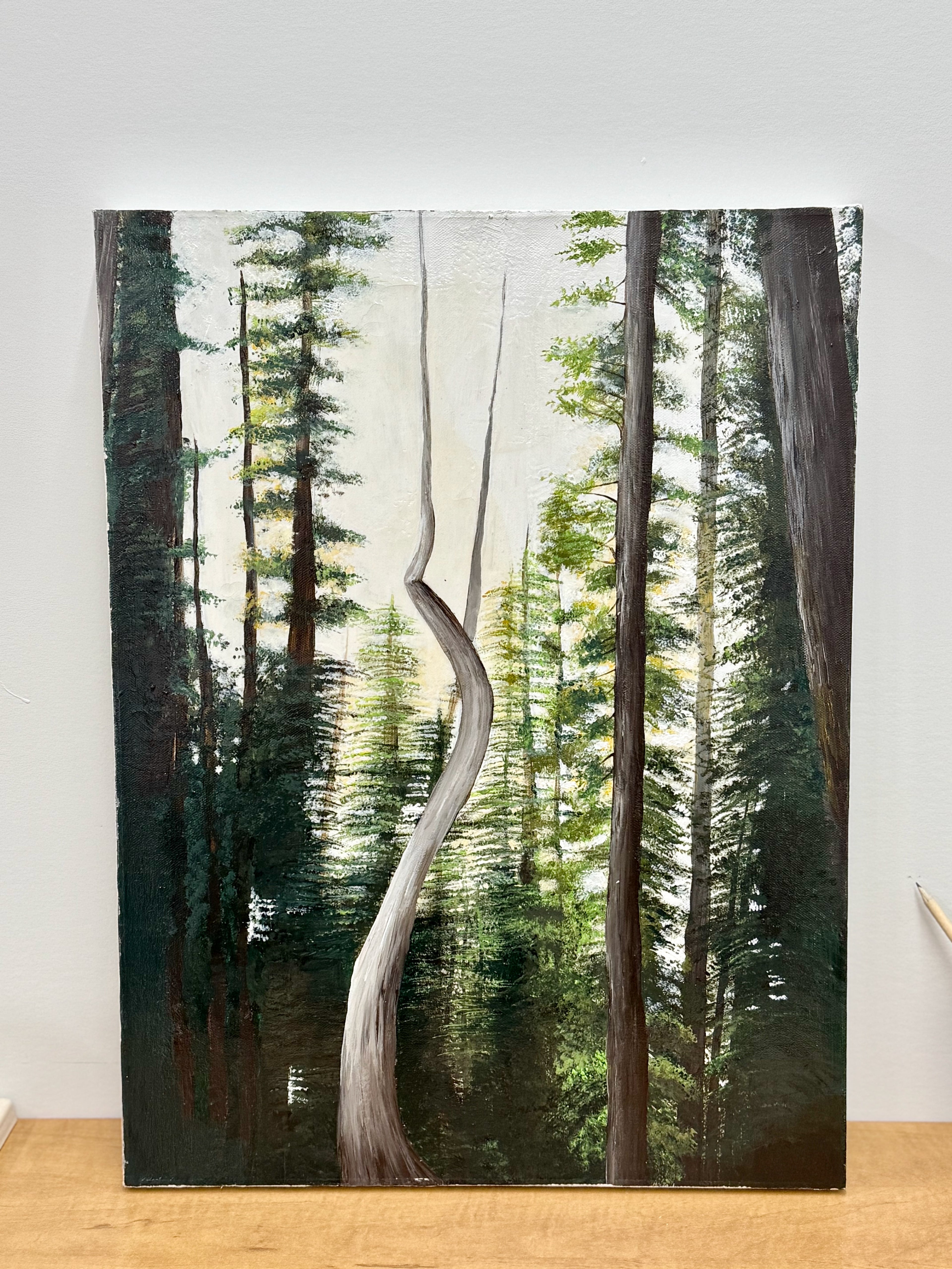 Forest scene with a curved tree trunk in the center, on a wooden surface.