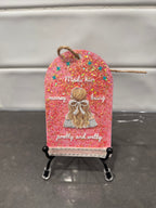 Decorative pink tag with a girl illustration and text on a stand against a white background