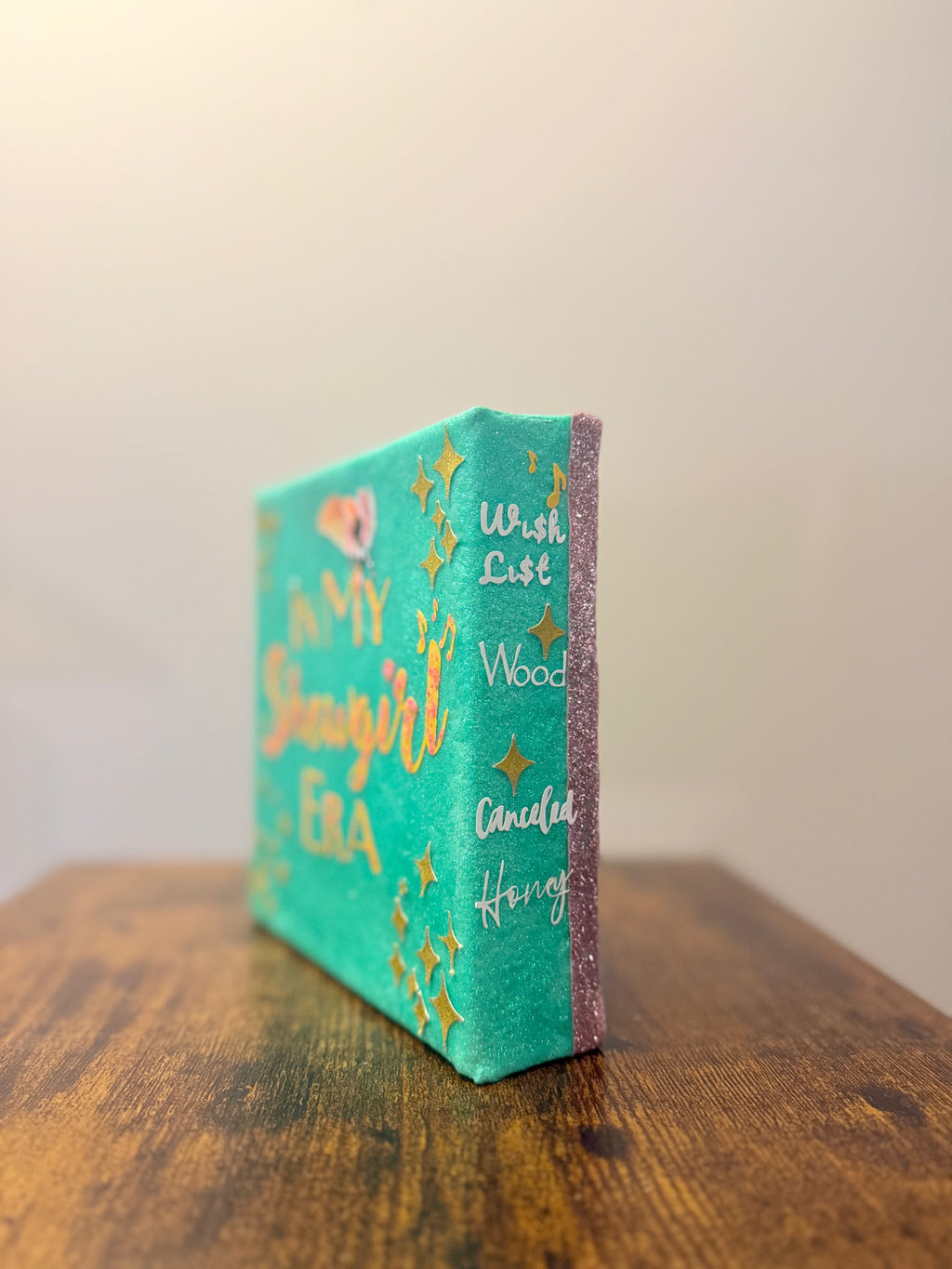 Small decorative box with text and star designs on a wooden surface