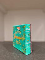 Small decorative box with text and star designs on a neutral background