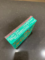 Teal book with gold text on a gray surface